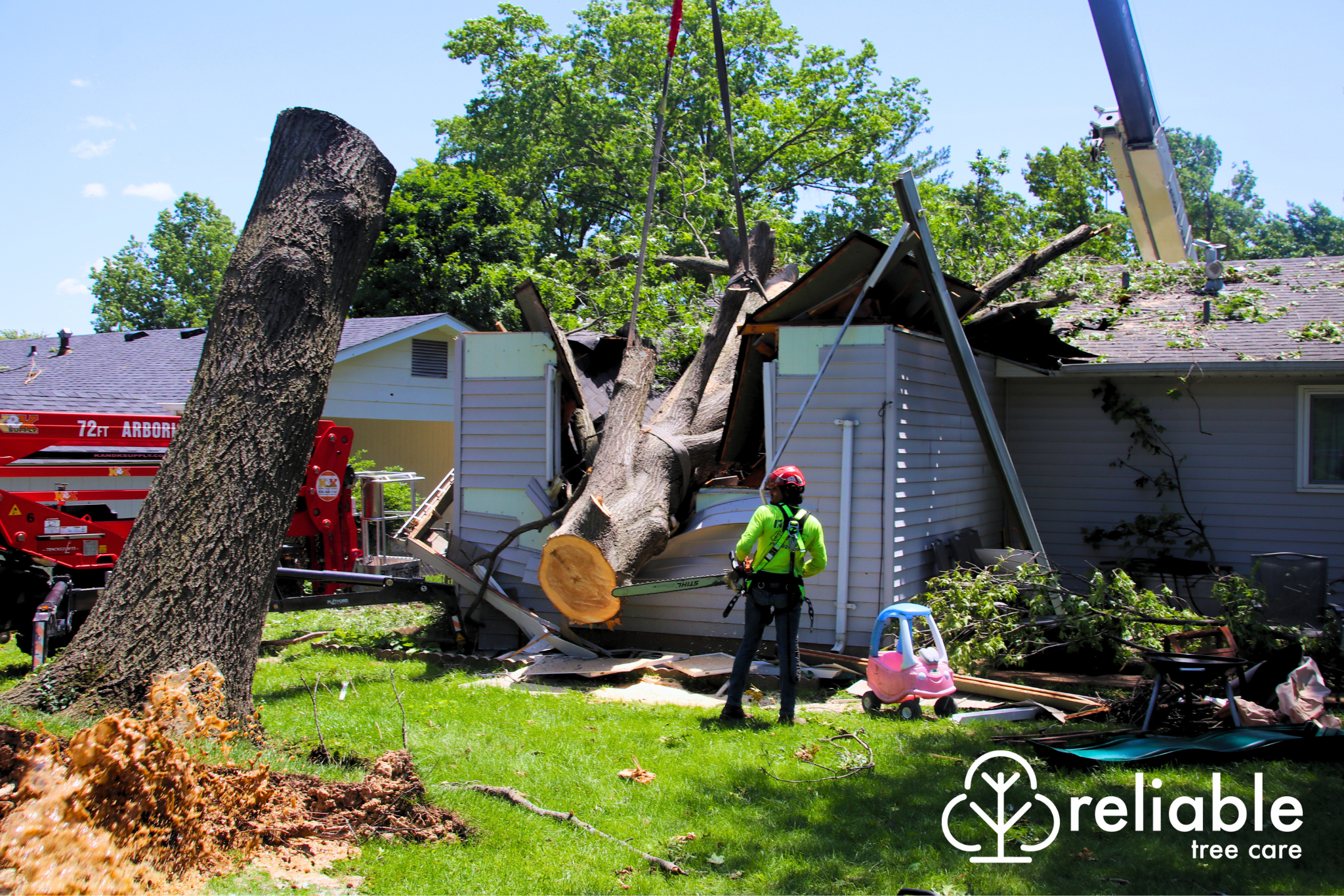 Crew member assessing damage of tree fallen on house from storm